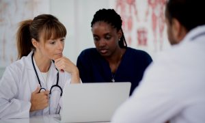 Healthcare providers looking at a laptop computer